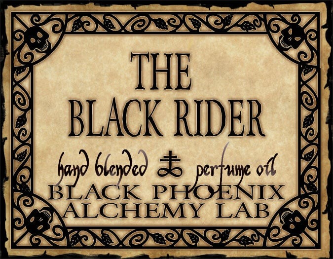 Label for 'The Black Rider' perfume oil by Black Phoenix Alchemy Lab with decorative border and text.