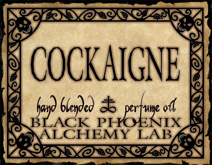 Label for 'Cockaigne' hand blended perfume oil by Black Phoenix Alchemy Lab with decorative border.