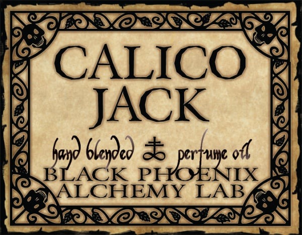 Label for 'Calico Jack' hand blended perfume oil by Black Phoenix Alchemy Lab with decorative border.