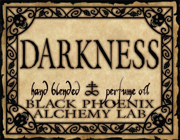 Label for 'Darkness' hand blended perfume oil by Black Phoenix Alchemy Lab with decorative border.