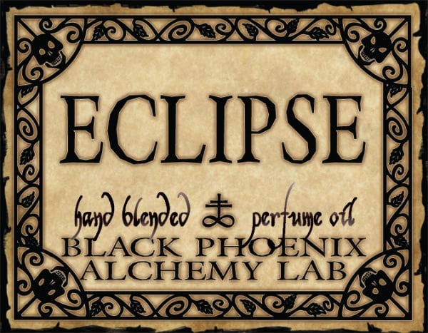 Label for 'Eclipse' hand blended perfume oil by Black Phoenix Alchemy Lab with decorative border.