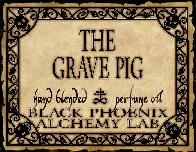 Label for 'The Grave Pig' hand blended perfume oil by Black Phoenix Alchemy Lab with decorative border.