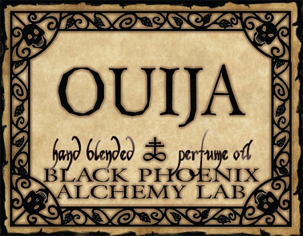Ouija label for a hand blended perfume oil by Black Phoenix Alchemy Lab with decorative border.