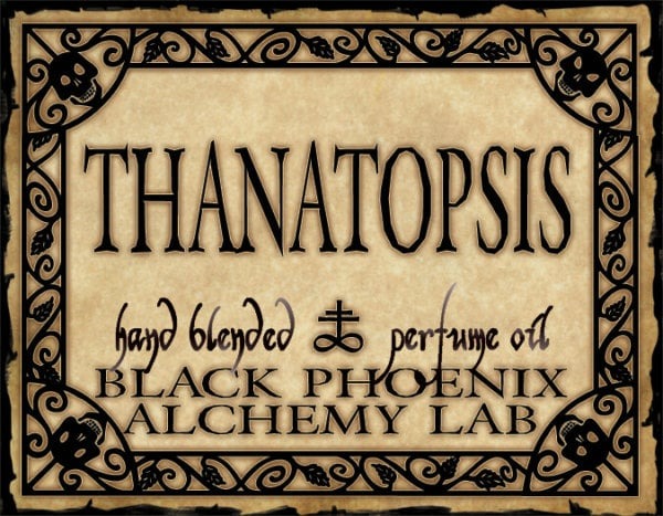 Label for 'Thanatopsis' hand blended perfume oil by Black Phoenix Alchemy Lab with decorative border.