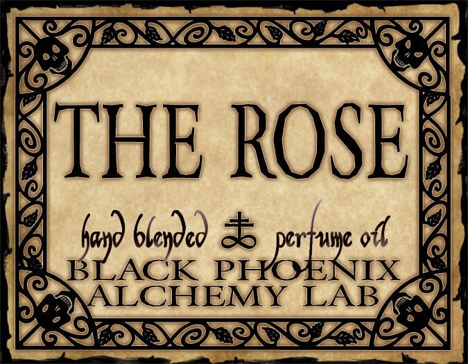 Label for 'The Rose' hand blended perfume oil by Black Phoenix Alchemy Lab with decorative border.