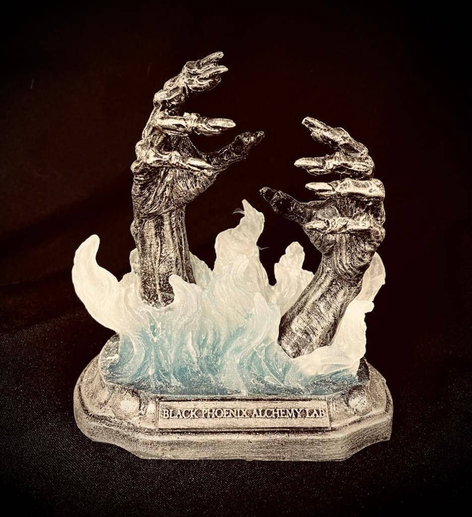 Decorative figurine of hands emerging from flames with 'Black Phoenix Alchemy Lab' branding on a dark background.