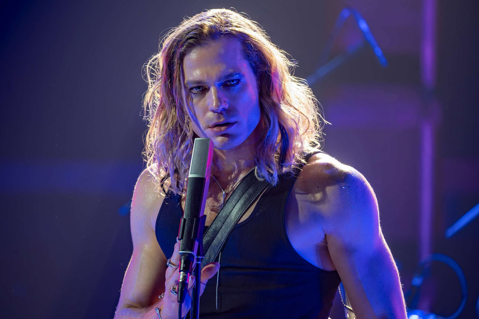 Lestat de Lioncourt gripping a microphone stand under blue and purple stage lights — The Vampire Lestat x AMC, Interview with the Vampire Season 3

