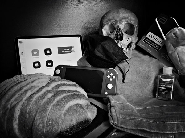 Pandemic vanitas with skull, switch, sourdough, mask, hand sanitizer, covid test, and zoom meeting